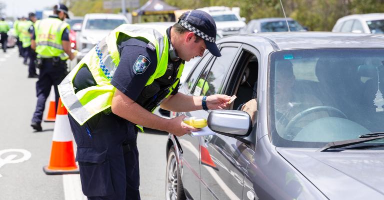 Police conducting breathalyser test at road safety checkpoint