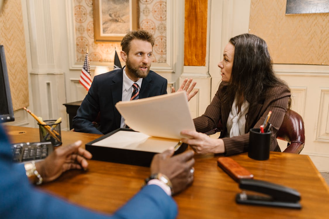 A family law solicitor reviewing legal documents at an office desk.